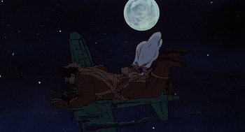 Movie still from “Heavy Metal” (1981), directed by Gerald Potterton – An animated scene of a man laying on a plane in front of the moon; Wide shot, Low angle
