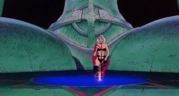 Movie still from “Heavy Metal” (1981), directed by Gerald Potterton – A woman in lingerie stands in front of a giant statue; Extreme Wide shot, Low angle
