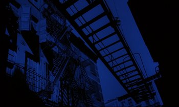 Movie still from “Heavy Traffic” (1973), directed by Ralph Bakshi – A building with a fire escape on the side of the building; Extreme Wide shot, Low angle