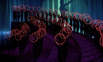 Movie still from “Heavy Traffic” (1973), directed by Ralph Bakshi – A group of people standing next to each other holding hula hoops; Extreme Wide shot, High angle