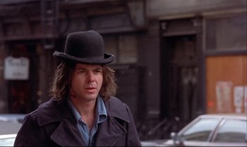 Movie still from “Heavy Traffic” (1973), directed by Ralph Bakshi – A man in a black hat is walking down the street; Close Up shot, Low angle