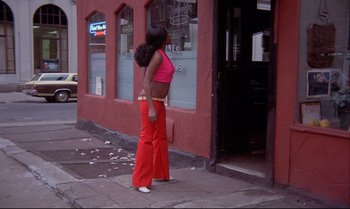 Movie still from “Heavy Traffic” (1973), directed by Ralph Bakshi – A woman standing on the side of the street; Wide shot, Low angle