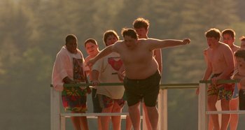 Movie still from “Heavyweights” (1995), directed by Steven Brill – A group of people standing on top of a bridge; Wide shot, Low angle
