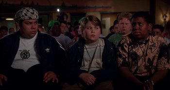 Movie still from “Heavyweights” (1995), directed by Steven Brill – A group of people sitting in front of a crowd; Medium shot, High angle