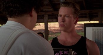 Movie still from “Heavyweights” (1995), directed by Steven Brill – A man standing next to another man in front of a building; Close Up shot, Over the shoulder angle