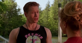 Movie still from “Heavyweights” (1995), directed by Steven Brill – A man in a black tank top talking to another man; Medium shot, Over the shoulder angle