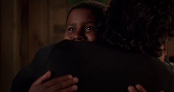 Movie still from “Heavyweights” (1995), directed by Steven Brill – Two people hugging each other in a dark room; Close Up shot, Over the shoulder angle
