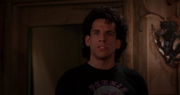 Movie still from “Heavyweights” (1995), directed by Steven Brill – A man with curly black hair wearing a black shirt; Close Up shot, Over the shoulder angle