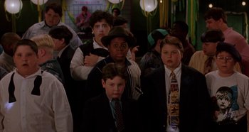Movie still from “Heavyweights” (1995), directed by Steven Brill – A group of young men standing next to each other in suits; Medium shot, High angle