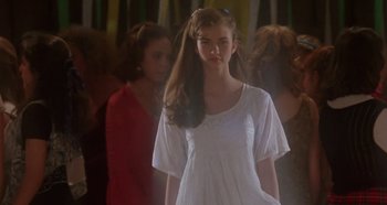 Movie still from “Heavyweights” (1995), directed by Steven Brill – A young girl in a white dress is standing in front of other young girls; Medium shot, Over the shoulder angle