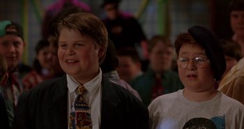 Movie still from “Heavyweights” (1995), directed by Steven Brill – Two young men in suits and ties smiling for the camera; Medium shot, Low angle