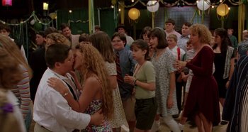 Movie still from “Heavyweights” (1995), directed by Steven Brill – A group of people standing around each other in a room; Medium shot, Over the shoulder angle