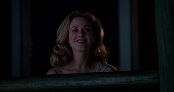 Movie still from “Heavyweights” (1995), directed by Steven Brill – A woman smiling for the camera in the dark; Medium shot, Low angle