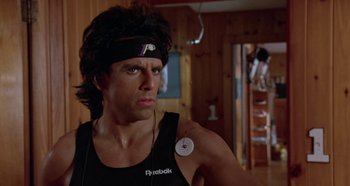 Movie still from “Heavyweights” (1995), directed by Steven Brill – A man wearing a headband and a black tank top; Close Up shot, Low angle