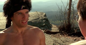 Movie still from “Heavyweights” (1995), directed by Steven Brill – A man with no shirt and no shirt is standing on a cliff; Close Up shot, Low angle
