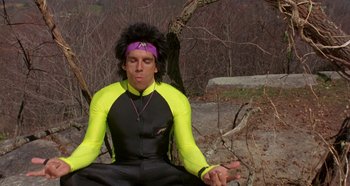 Movie still from “Heavyweights” (1995), directed by Steven Brill – A man sitting in the middle of a forest wearing a yellow shirt; Medium shot, High angle