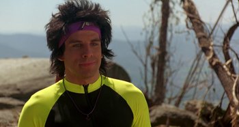 Movie still from “Heavyweights” (1995), directed by Steven Brill – A man in a yellow and black shirt with a purple headband; Close Up shot, Over the shoulder angle