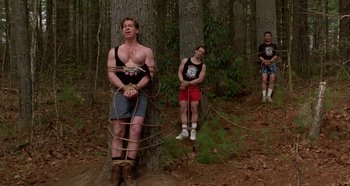 Movie still from “Heavyweights” (1995), directed by Steven Brill – A group of people tied to a tree in the woods; Wide shot, Low angle