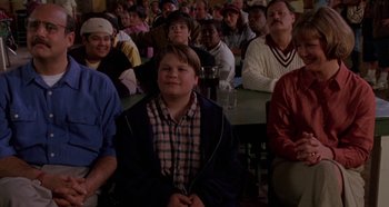 Movie still from “Heavyweights” (1995), directed by Steven Brill – A group of people sitting in front of a crowd; Medium shot, High angle