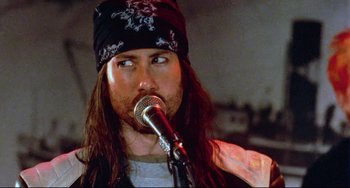 Movie still from “Hedwig and the Angry Inch” (2001), directed by John Cameron Mitchell – A person holding a microphone; Close Up shot, Over the shoulder angle