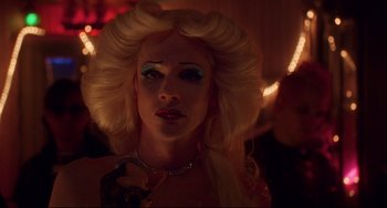 Movie still from “Hedwig and the Angry Inch” (2001), directed by John Cameron Mitchell – A woman with blonde hair and a necklace; Close Up shot, Over the shoulder angle
