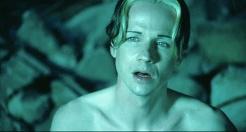 Movie still from “Hedwig and the Angry Inch” (2001), directed by John Cameron Mitchell – A man with blonde hair and blue eyes looking at the camera; Close Up shot, High angle