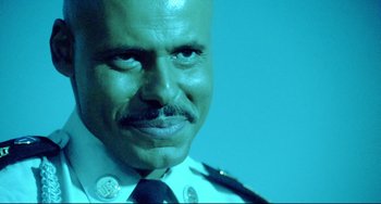 Movie still from “Hedwig and the Angry Inch” (2001), directed by John Cameron Mitchell – A man in a police uniform; Close Up shot, Over the shoulder angle