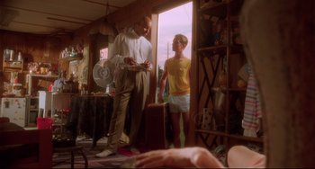 Movie still from “Hedwig and the Angry Inch” (2001), directed by John Cameron Mitchell – A man and a woman standing next to each other in a room; Wide shot, Low angle