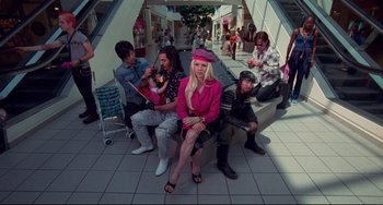 Movie still from “Hedwig and the Angry Inch” (2001), directed by John Cameron Mitchell – A group of people sitting on top of a wooden bench; Wide shot, High angle