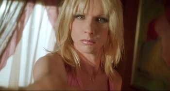 Movie still from “Hedwig and the Angry Inch” (2001), directed by John Cameron Mitchell – A woman with blonde hair and a pink top; Close Up shot, High angle