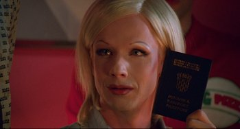 Movie still from “Hedwig and the Angry Inch” (2001), directed by John Cameron Mitchell – A woman with blonde hair holding a passport in her hand; Close Up shot, Overhead angle