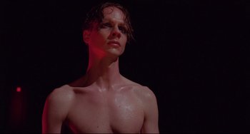 Movie still from “Hedwig and the Angry Inch” (2001), directed by John Cameron Mitchell – A shirtless man with wet hair is looking at the camera; Close Up shot, Low angle