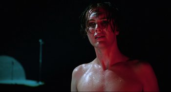 Movie still from “Hedwig and the Angry Inch” (2001), directed by John Cameron Mitchell – A shirtless man with wet hair and no shirt in a dark room; Close Up shot, Low angle