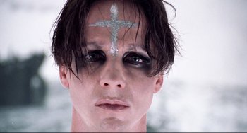 Movie still from “Hedwig and the Angry Inch” (2001), directed by John Cameron Mitchell – A man with a cross painted on his forehead; Close Up shot, Low angle