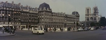 Movie still from “Hell and High Water” (1954), directed by Samuel Fuller – People walking on the sidewalk in front of a large building; Extreme Wide shot, High angle
