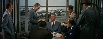 Movie still from “Hell and High Water” (1954), directed by Samuel Fuller – A group of men sitting around a table; Medium shot, Low angle