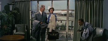 Movie still from “Hell and High Water” (1954), directed by Samuel Fuller – A man and a woman standing next to each other at an airport; Wide shot, Low angle