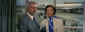 Movie still from “Hell and High Water” (1954), directed by Samuel Fuller – An older man standing next to an older woman in front of an airplane; Medium shot, Low angle