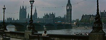 Movie still from “Hell and High Water” (1954), directed by Samuel Fuller – A man sitting on a bench in front of a river and big ben; Extreme Wide shot, High angle