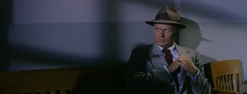 Movie still from “Hell and High Water” (1954), directed by Samuel Fuller – A man wearing a suit and a hat; Close Up shot, High angle