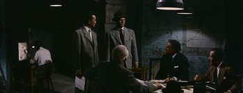 Movie still from “Hell and High Water” (1954), directed by Samuel Fuller – A group of men standing around a table; Medium shot, High angle