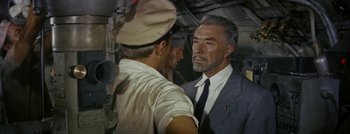 Movie still from “Hell and High Water” (1954), directed by Samuel Fuller – A man in a suit talking to another man in a uniform; Medium shot, High angle