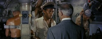 Movie still from “Hell and High Water” (1954), directed by Samuel Fuller – A man wearing a hat talking to a man in a suit; Medium shot, High angle