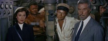 Movie still from “Hell and High Water” (1954), directed by Samuel Fuller – A man in a white shirt and a hat is standing next to another man in a white shirt; Medium shot, High angle