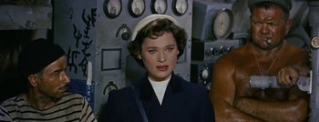 Movie still from “Hell and High Water” (1954), directed by Samuel Fuller – A woman in a navy blue uniform with a white hat; Close Up shot, Low angle