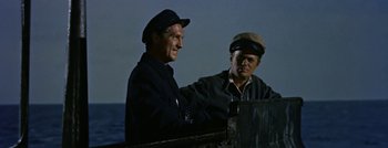 Movie still from “Hell and High Water” (1954), directed by Samuel Fuller – Two men are sitting next to each other on a boat; Medium shot, Low angle