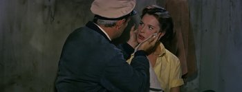 Movie still from “Hell and High Water” (1954), directed by Samuel Fuller – A man and a woman talking on a cell phone; Close Up shot, Over the shoulder angle