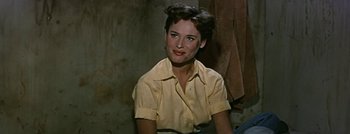 Movie still from “Hell and High Water” (1954), directed by Samuel Fuller – A woman in a yellow shirt sitting down; Close Up shot, High angle
