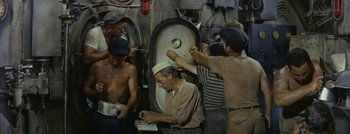 Movie still from “Hell and High Water” (1954), directed by Samuel Fuller – A group of men standing next to each other on a boat; Medium shot, High angle