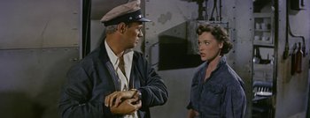 Movie still from “Hell and High Water” (1954), directed by Samuel Fuller – A man and a woman are standing in a room; Medium shot, High angle